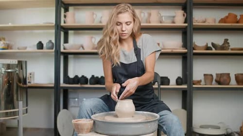 Woman Shaping Clay on Pottery Wheel in Studio
