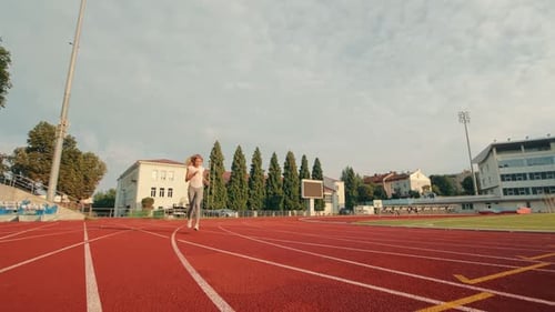 Blonde Woman Runs on Red Urban Track