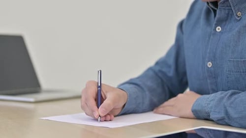 Männliche Hände schreiben auf Papier Nahaufnahme