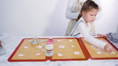 Zeitraffer. Schritt für Schritt. Kleines Mädchen hilft bei der Herstellung eines hausgemachten Lutschers mit Fondant-Schneeflocken
