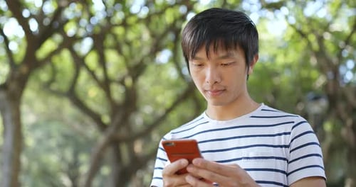 Young Adult Using Mobile Phone in Urban Park