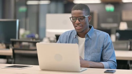 Young Man Video Conferencing on Laptop in Office