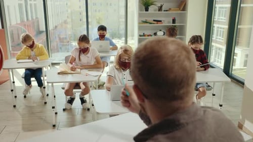 Children Studying with Masks in Bright Classroom
