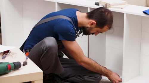 Travailleur de sexe masculin en combinaison vissant un boulon pour l'assemblage de meubles