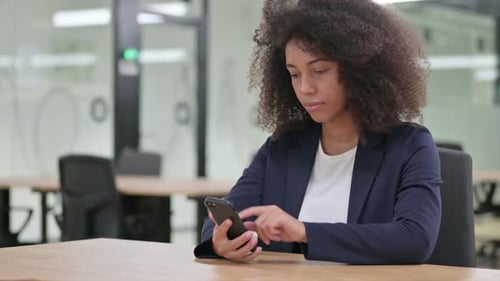 Woman Using Smartphone in Modern Office