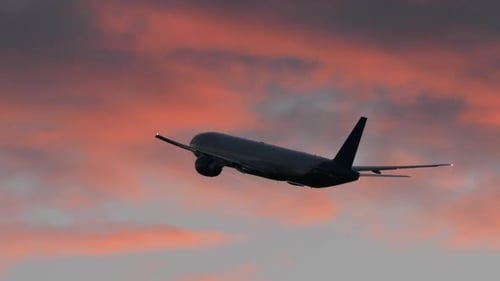 Plane Flying in Evening Cloudy Sky