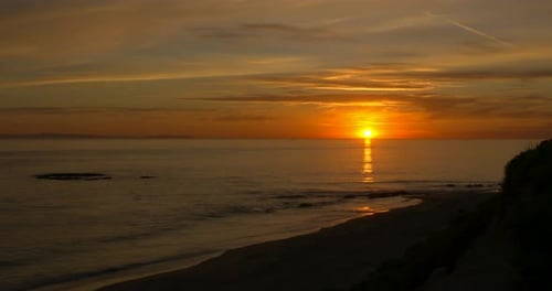 Time lapse of a beautiful, bright orange sunset over the Pacific Ocean in California