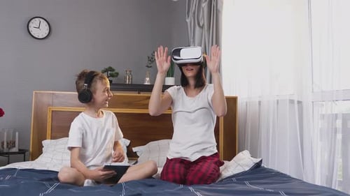 Woman with VR Headset Interacts, Boy Uses Tablet