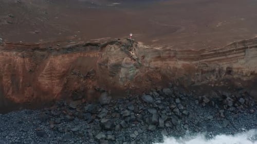 Homme debout sur le rocher du volcan Capelinhos, île de Faial, Açores, Portugal