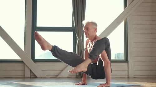 Man Practicing Yoga Pose on Mat Indoors