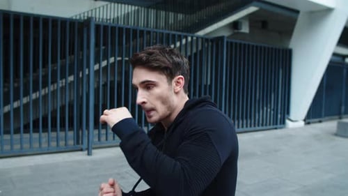 Man Training Boxing Moves Outdoors in Urban Setting