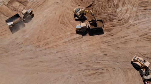 Bagger lädt Sand in einen großen LKW - Luftaufnahme
