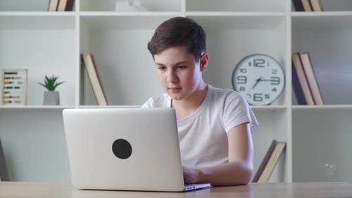Niño asustado sorprendido por una terrible escena mientras leía noticias de terror en la computadora