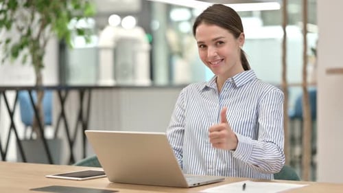 Cheerful Woman Working on Laptop Gives Thumbs Up