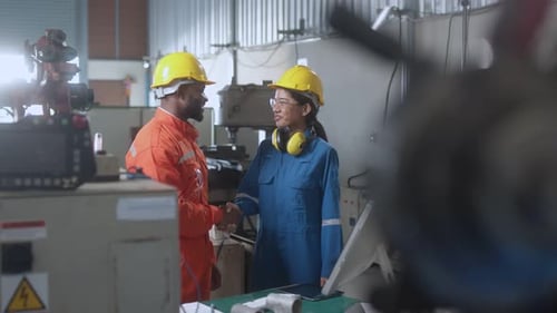 Factory Workers Shaking Hands in Industrial Workplace
