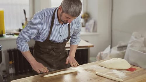 Baker Shaping Dough in a Bright Kitchen