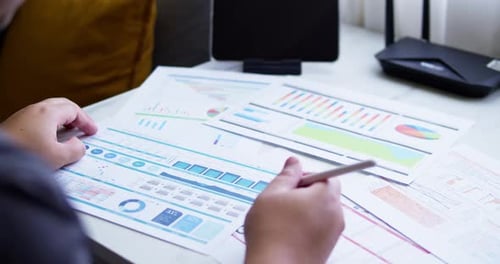 Close up of a dashboard chart and hands working on statistical and analytical data.