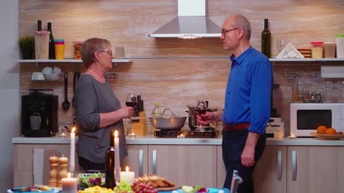 Senior Couple Talking over Wine in Cozy Kitchen