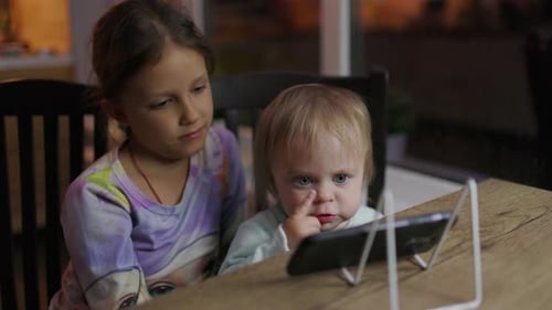 Children bonding watching a smartphone indoors
