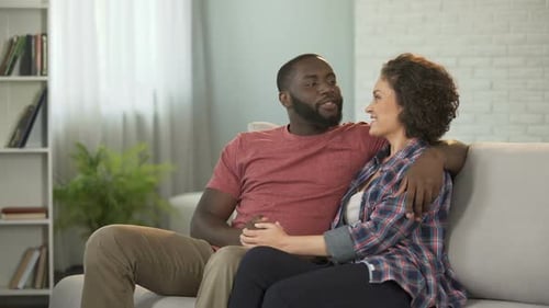 Affectionate Couple Cuddling Together on Couch at Home