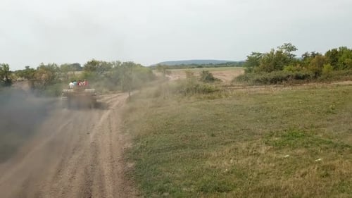 Tank Driving on Dirt Road Through Countryside