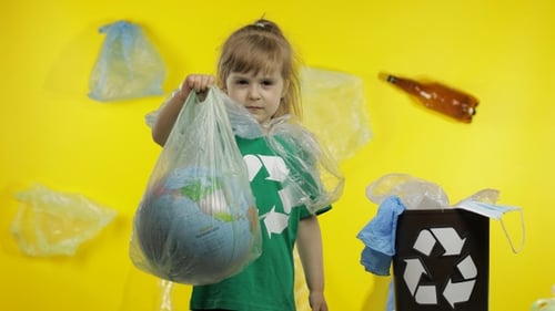 Niña activista con paquetes de celofán en el cuello. Reducir la contaminación plástica de la Tierra. Salva la ecología