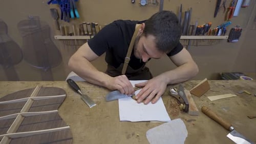 Artesano aplanando pieza de madera con rascador en sala de trabajo