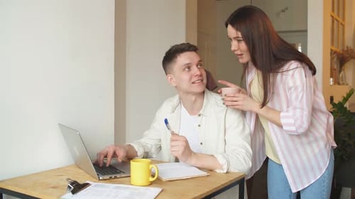 Young Couple Working Together on Laptop at Home