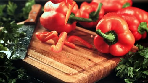 Red Bell Peppers Being Sliced on Wooden Board