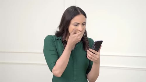 Shocked Woman Using Smartphone Indoors
