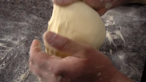 Men's hands hold dough. making raw dough for pizza, rolls or bread.