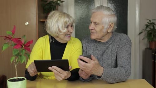 Senior Couple Using Tablet and Smartphone Together