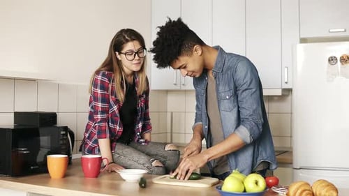 Young Adults Chatting While Preparing Food Indoors