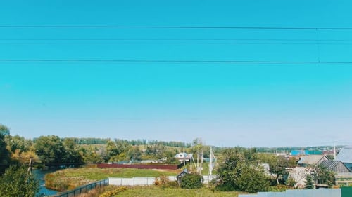Eine Landschaft aus einem Dorf und ein blauer Himmel - Schießen aus dem Zug