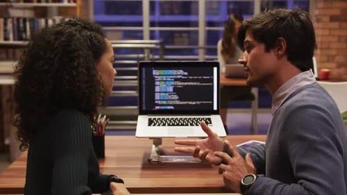 Creative businessman and bussinesswoman discussing over laptop in modern office
