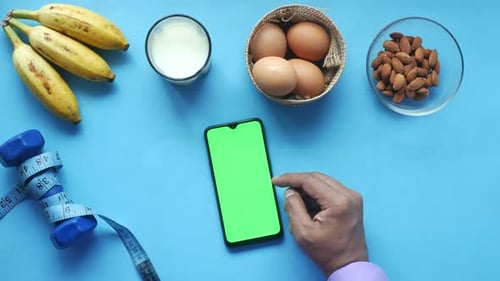 Smartphone with healthy food and fitness equipment