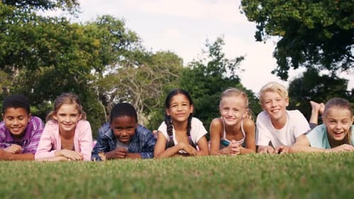Happy Children Lying Together on Green Grass