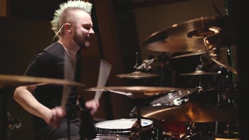 Drummer performing in a studio setting.