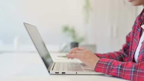 Person Typing on Laptop Keyboard in Office