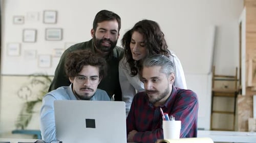 Smiling Coworkers Talking Via Laptop in Cozy Office