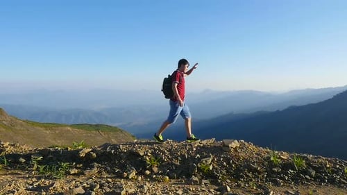 Young Adult Hiking on Top of Mountain Trail