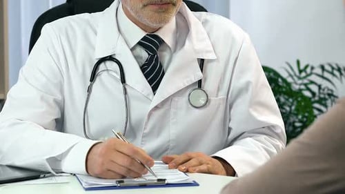 Doctor Writes Patient Notes in Exam Room
