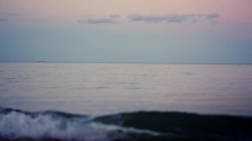 Ruhiger Horizont der Meeresoberfläche am rosa Himmel im kalten Morgengrauen