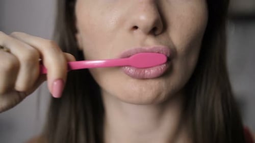 Young Adult Woman Brushing Her Teeth Close Up