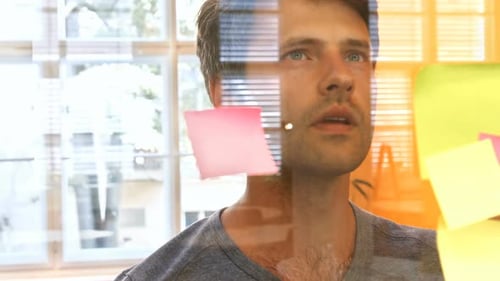 Man Brainstorming With Sticky Notes in Office