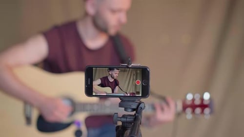 Man Records Guitar Performance with Mobile Phone