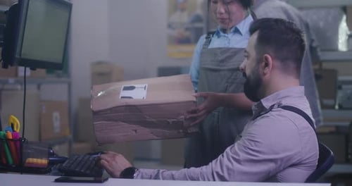 Arbeiter überprüfen beschädigtes Paket