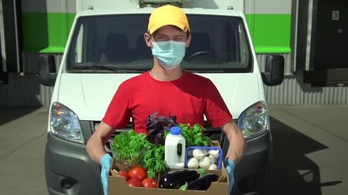 Young Adult Delivering a Box of Fresh Vegetables