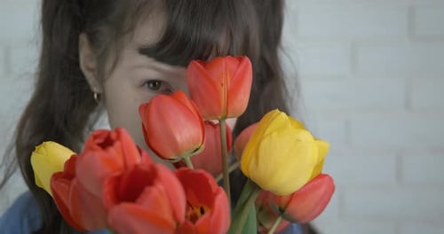 Smiling Girl Holding Vibrant Tulips Close-Up