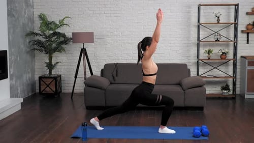 Woman Doing Lunges on Yoga Mat at Home